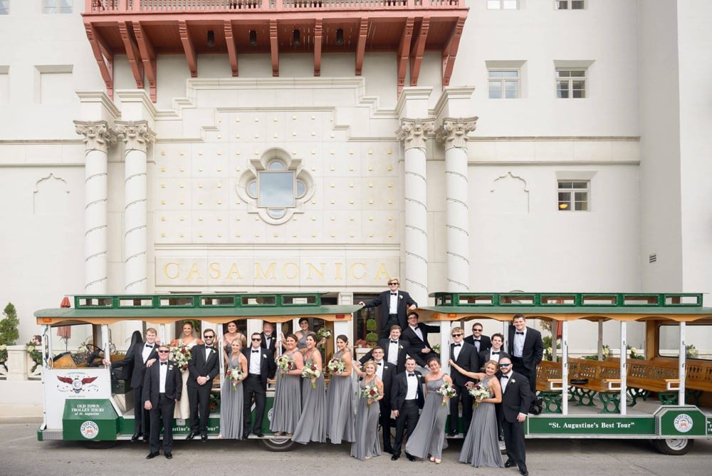 wedding party pose with green trolley in St. Augustine
