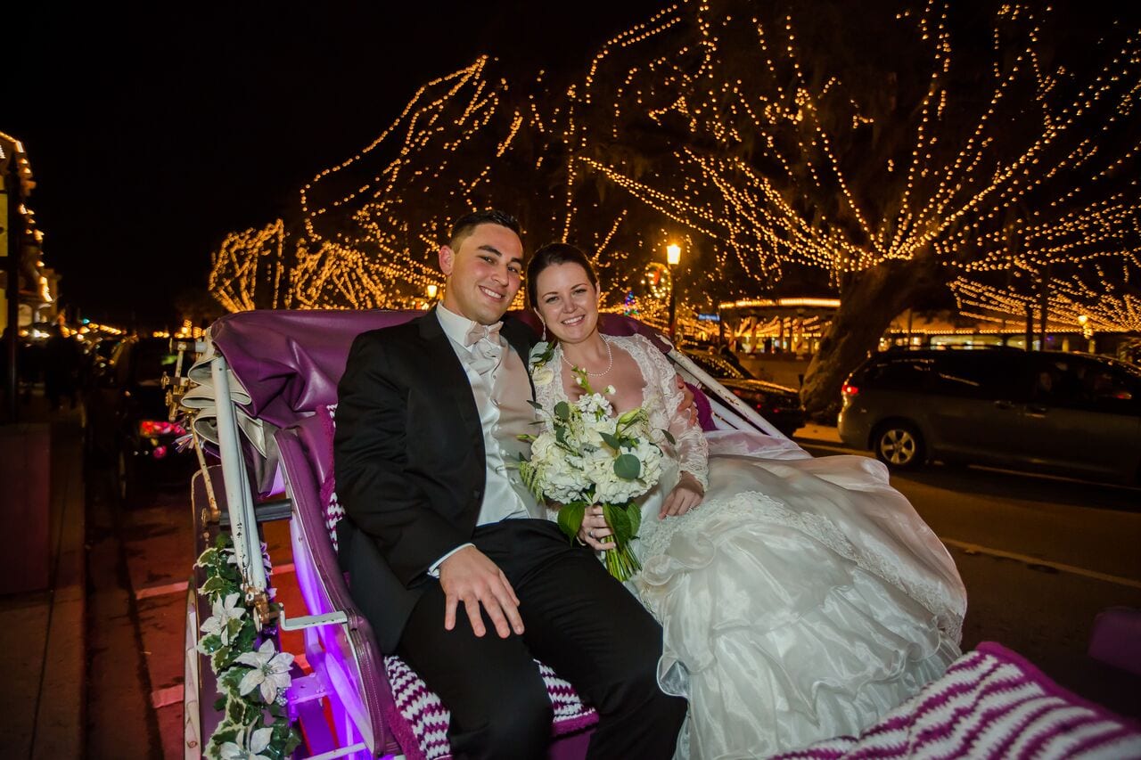 bride and groom sitting in horse-drawn carriage during Nights of Lights in St. Augustine