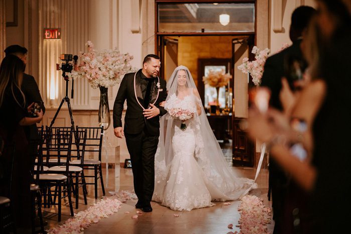 father and bride walk down the aisle | Glam Wedding with a Rock and Roll Surprise at The Treasury | Cristal + Steven