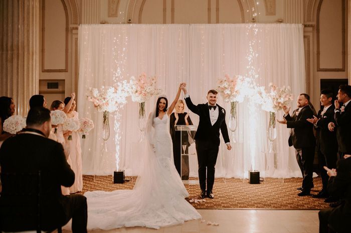 Bride and groom after exchanging vows with cold sparklers behind them