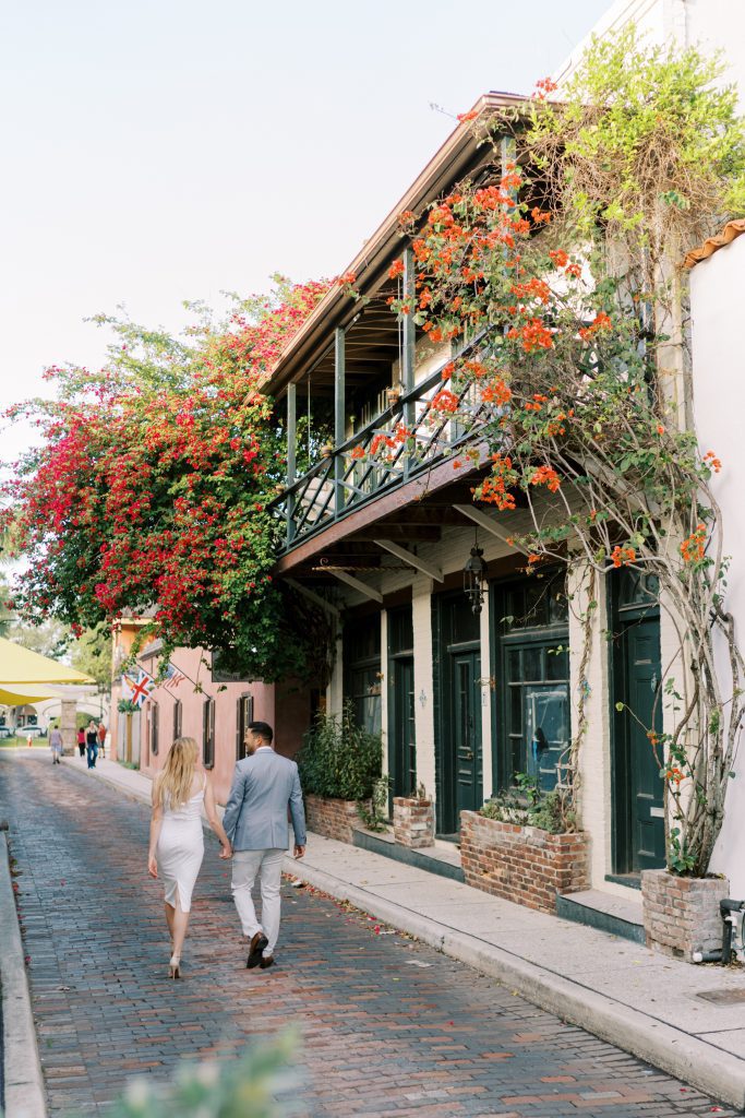 engaged couple walking down cobblestone streets in St. Augustine Florida