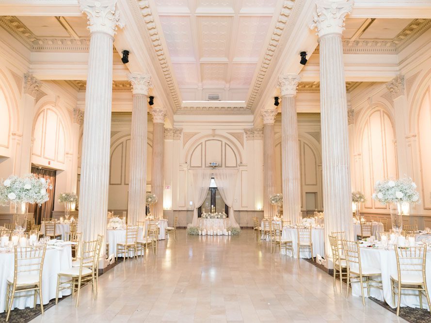Reception tables set for dinner inside the Grand Ballroom at The Treasury on the Plaza.