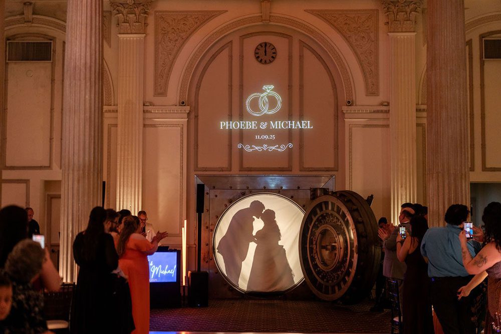Newlyweds making a silhouette entrance in the historic vault door
